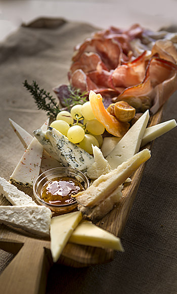 Zusammenstellung von Wurst- und Käsesorten, die auf einem Tablett präsentiert werden